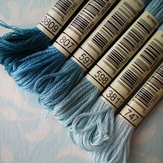 four skeins of blue yarn sitting next to each other on a tablecloth