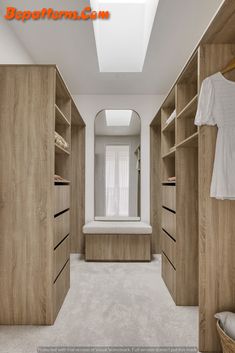 an empty walk in closet with wooden cabinets and white carpeted flooring is shown