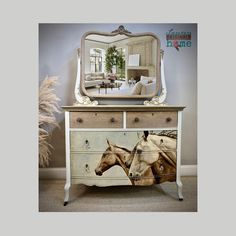 a dresser with a horse painted on the side and a large mirror over it's top