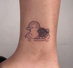 a small tattoo on the ankle of a woman's foot with a duck swimming in water