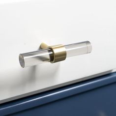 a close up of a door handle on a white and blue cabinet