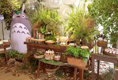 an assortment of plants and food on display in a room with a totoro decoration