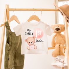 a teddy bear and t - shirt hanging on a clothes rack