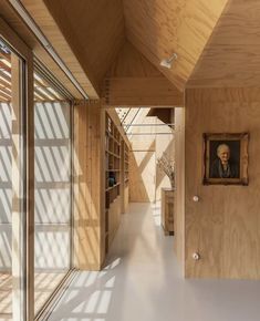 an empty hallway with wooden walls and windows