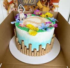 a cake in a cardboard box with flowers on the top and an image of elvis