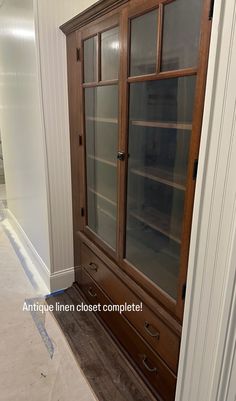 a large wooden cabinet with glass doors in a room