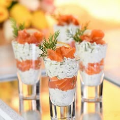 small glasses filled with food sitting on top of a table