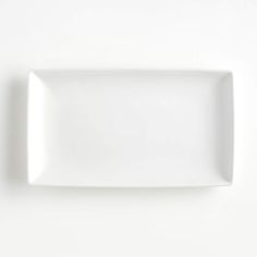 an empty white plate sitting on top of a table