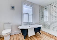 a bathroom with a claw foot tub, toilet and shower