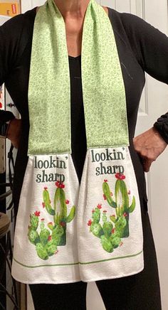 a woman wearing a green and white scarf with the words lookin'sharp on it