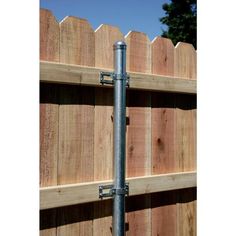 a metal pipe is attached to a wooden fence