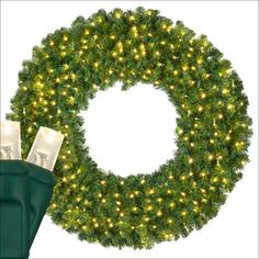 a christmas wreath with lights on it next to a pair of green rubber boots and a white background