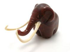 an elephant figurine made out of wood and plastic with long tusks