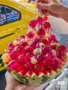 a watermelon fruit bowl with grapes and cherries in it