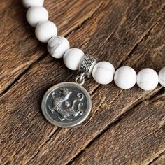 About Specifications Complete your outfit with our Howlite - White Tiger Bracelet (6mm). The bracelet is finished with a silver tiger bead & coin. Handcrafted in The Netherlands by professional artisans with the best Nature has to offer and finished with 925 Sterling Silver. - Gems: Howlite - Stone size: 6mm - Metal: 925 Sterling silver - Cord: High-end durable silicone - Packaging: Comes with a linen pouch. (Due to the unique characteristics of natural stone, the size and color of the beads can vary slightly.) White Howlite Bracelets With Natural Stones, Howlite Natural Stone Bracelet, White Howlite Bohemian Bracelet, Tigers Bracelet, White Howlite Bracelet, Unique Opal, Howlite Stone, White Tiger, Jasper Stone