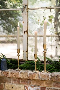 three candles sitting on top of a window sill