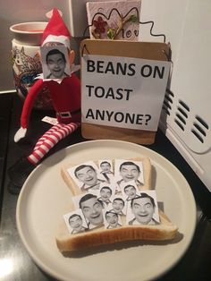 an elf is sitting on the counter next to toast with pictures of people's faces