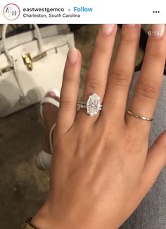 a woman's hand with a diamond ring on it