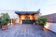 an outdoor patio with potted plants and bar