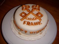 there is a white cake with gold letters on it that says frank by the plate