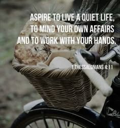 a bicycle with a basket full of bread on the front and side, saying aspire to live a quiet life, to mind your own affairs and to work with your hands