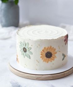 a white cake with sunflowers painted on it