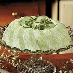 a cake with cucumbers on top is sitting on a table