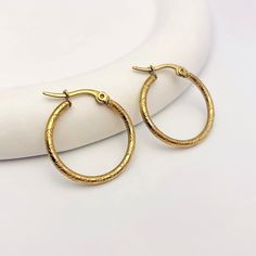 Elevate your everyday style with these sophisticated gold hoop earrings. Featuring a textured, ribbed design, these hoops add a touch of modern elegance to any outfit. The classic hoop shape is a timeless accessory that effortlessly complements a variety of looks. Elegant Gold-tone 14k Gold Filled Hoop Earrings, Textured Gold Plated Hoop Earrings, Elegant Gold-tone Tarnish Resistant Hoop Earrings, Classic Gold-tone Tarnish Resistant Hoop Earrings, Textured Gold-plated Hoop Earrings, Elegant Textured Gold Plated Hoop Earrings, Chic Gold-tone Brass Hoop Earrings, Yellow Gold Tarnish-resistant Brass Hoop Earrings, Custom Earrings