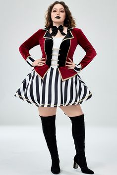 a woman in a striped skirt and jacket posing for the camera with her hands on her hips