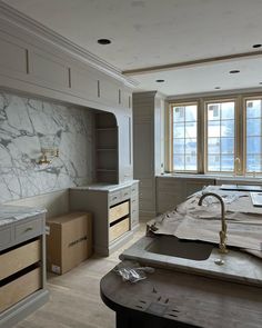 a large kitchen with marble counter tops and cabinets