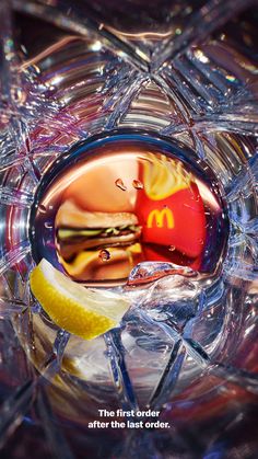 a mcdonald's advertisement is reflected in a glass bowl with lemon wedges and ketchup