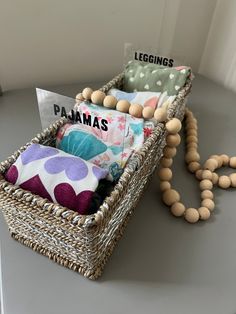 a wicker basket filled with pillows and beads on top of a table next to a sign that says legings