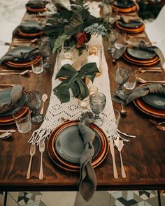 the table is set with plates, silverware and greenery for an elegant look