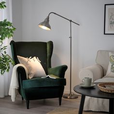 a living room with a green chair and lamp