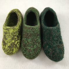 three pairs of slippers sitting on top of a white surface