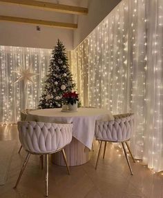 a christmas tree sitting on top of a table next to two chairs