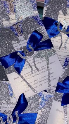 blue and silver glitter paper with scissors on it's side, surrounded by ribbon