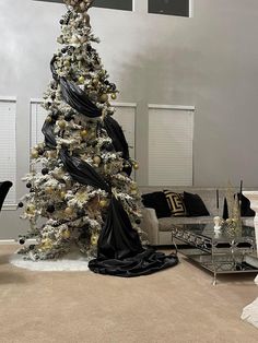 a decorated christmas tree in the middle of a living room with black and white decorations