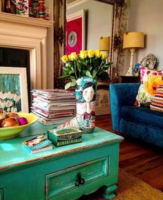 a living room filled with furniture and a fire place next to a blue couch covered in pillows