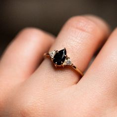 a woman's hand with a black and white diamond ring on top of her finger