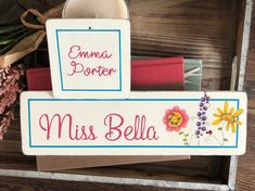 two personalized wooden signs sitting on top of each other next to flowers and candles