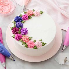 there is a cake decorated with flowers and icing on the table next to other decorations