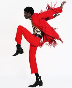 a man in red is doing a trick with his legs spread out and one leg up