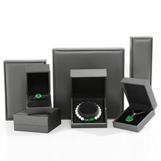 an assortment of jewelry in black boxes on a white background