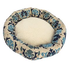 a blue and white dog bed with a flower pattern on it