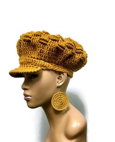 a mannequin head wearing a crocheted hat with large earrings on it