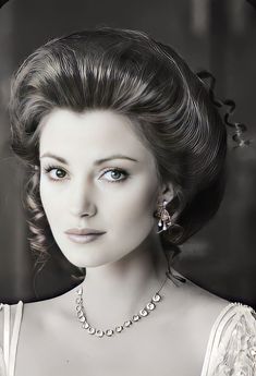 an old black and white photo of a woman with pearls in her hair wearing a necklace