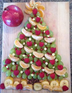 a christmas tree made out of fruit on a cutting board