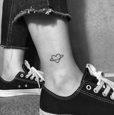 a small heart tattoo on the ankle