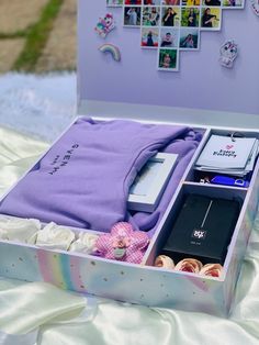 an open suitcase with items inside sitting on a bed covered in white sheets and pictures